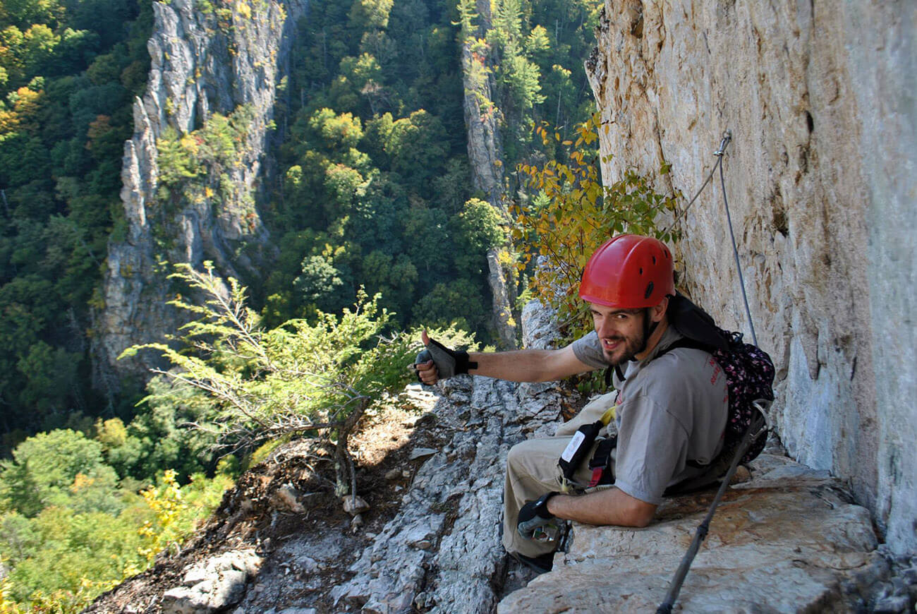 Man enjoying the stunning view from the Nelson Rocks Via Ferrata, a via ferrata in West Virginia.