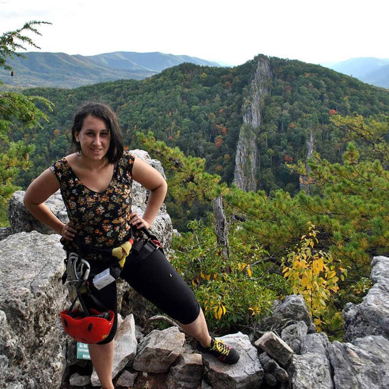 Frau, die den Nelson Rocks Klettersteig mit Flossen in der Ferne absolviert hat! 