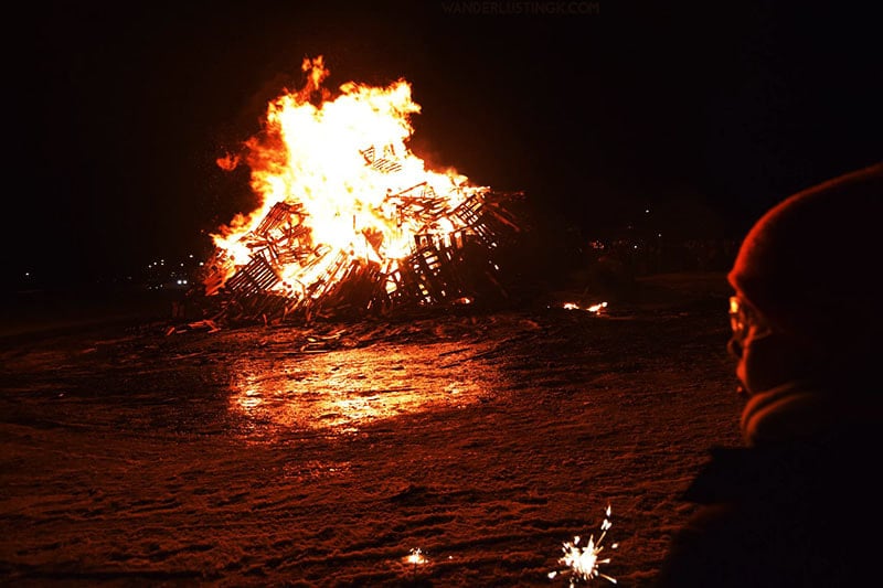 Kind beobachtet Lagerfeuer in Reykjavik. Tipps für die beste Stadt in Europa, in der man Silvester feiern kann: Reykjavik und was man an Silvester in Island unternehmen kann