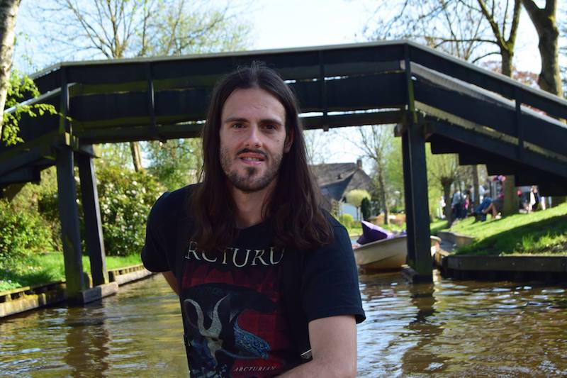 Man boating around Giethoorn, the Venice of the North. Read tips on how to get from Amsterdam to Giethoorn and tips for visiting Giethoorn, the most beautiful village in the Netherlands! #Netherlands #Travel #Dutch