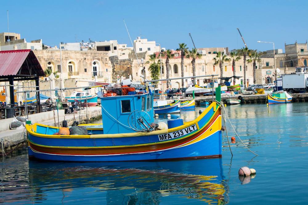 Traditional Maltese boats in Marsaxlokk, one of the most beautiful cities in Malta. Read why you must include Marsaxlokk in your Malta itinerary! #travel #malta #Marsaxlokk #europe #beautifulplaces