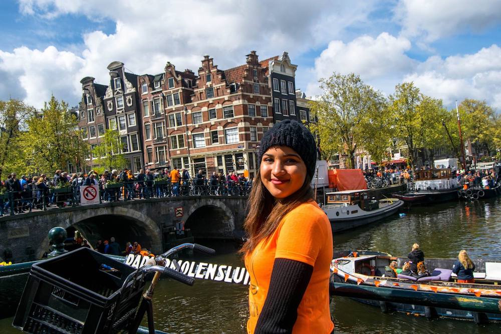 Girl dressed up for King's Day in Amsterdam, the Netherlands. King's Day is one of the best Dutch holidays to celebrate. Read tips on what to know before visiting Amsterdam for King's Day! #Amsterdam #Netherlands #travel