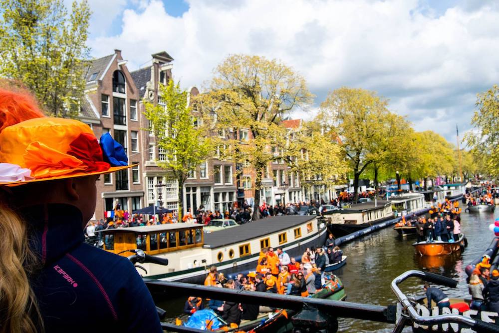 Canals of Amsterdam on Koningsdag, King's Day, in Amsterdam. This Dutch holiday is one of the best times of the year to visit in Amsterdam! #Amsterdam #Netherlands #travel