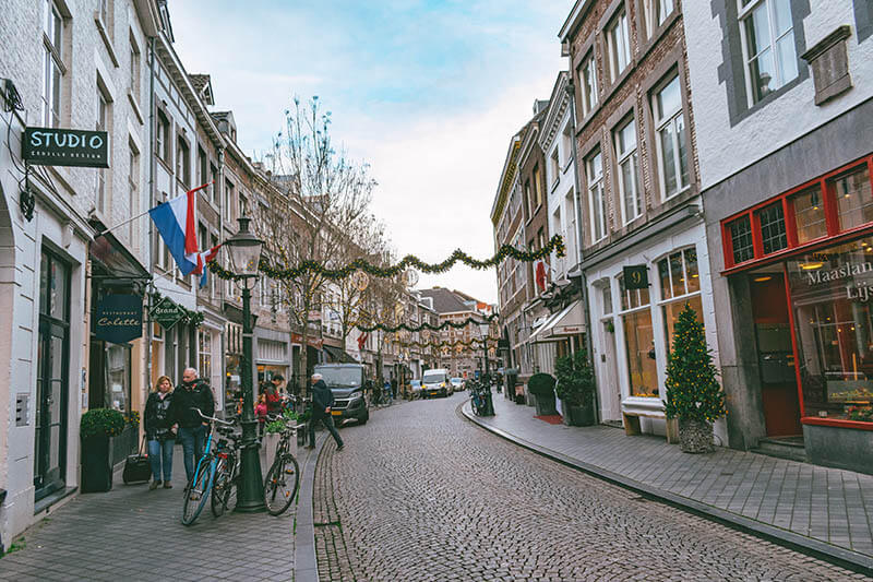 Belebte Straße mit Geschäften und Häusern im Stadtteil Wyck in Maastricht, einem der aufstrebenden Stadtteile Maastrichts, die es zu erkunden gilt