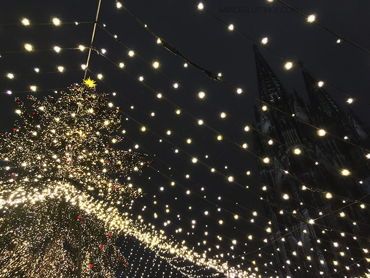 Photo of Christmas lights in Cologne with Cologne Cathedral in background. Read about the best Christmas markets with tips for visiting Cologne in December