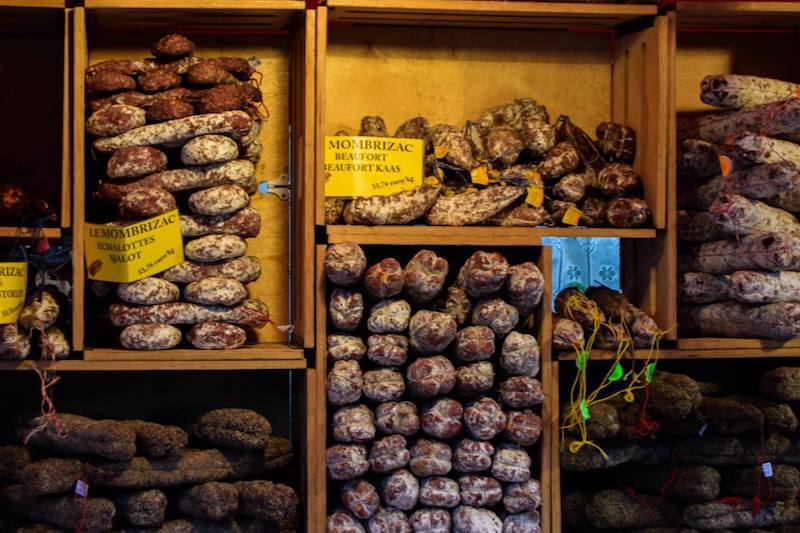 Photo of meats in the weekly Sunday market in Bomal Belgium. See why you should visit Wallonia!