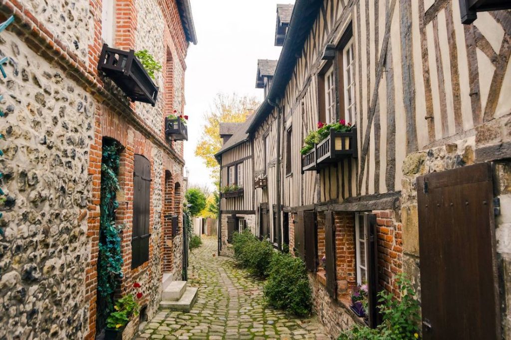 Beautiful city of Honfleur in France. Read what to bring to Europe for two weeks in this guide by an American expat in Europe who travels carry-on in Europe. Your ultimate guide to packing light for Europe! #travel #europe #france #honfleur