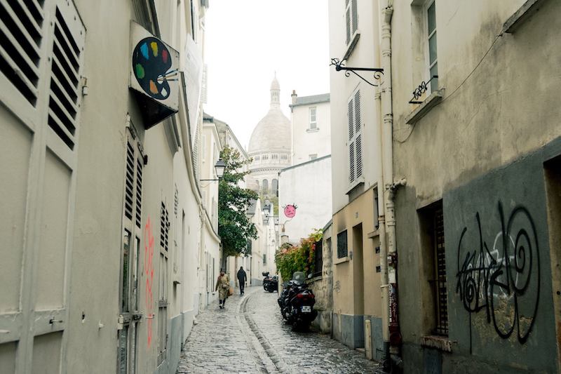 View of streets in Montmartre, a former village in Paris. This former village is perfect for a long walk. Read the perfect two hour itinerary for exploring Montmartre (the 18th arrondissement of Paris). #travel #Paris #Montmartre 