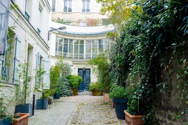 Leafy secret street in Paris in Cité du Midi. This beautiful hidden village in Pigalle should not be missed on your trip to Montmartre! #travel #Paris #France