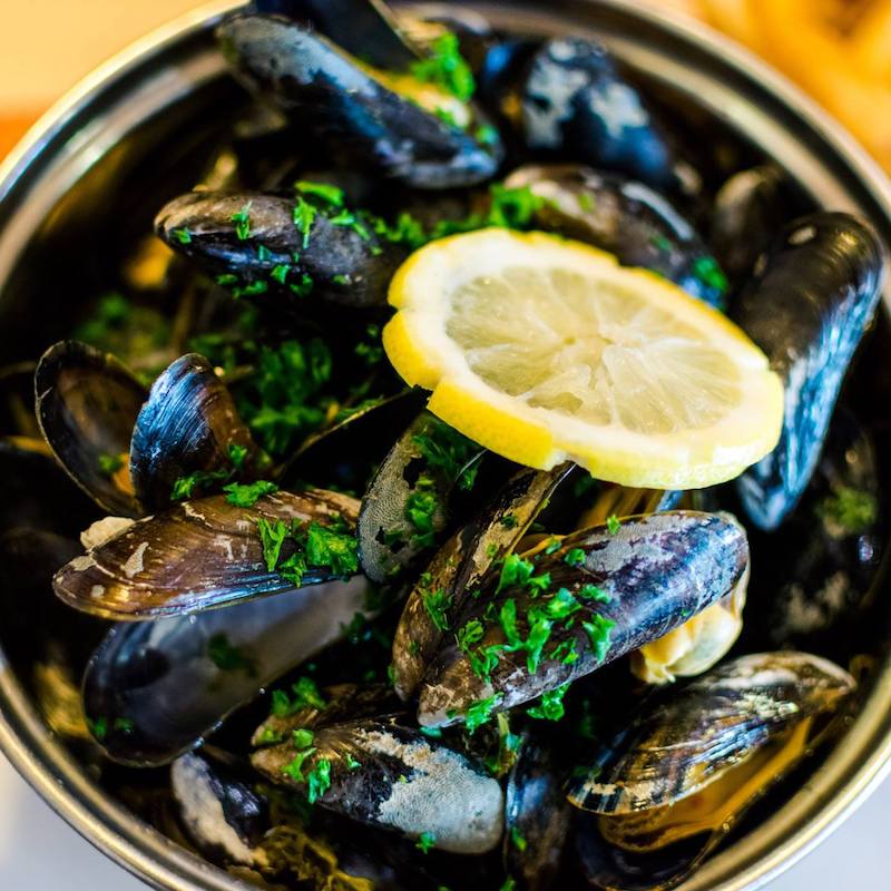 Mussels cooked with calvados in Fécamp, a coastal town in Normandy. Read what to do in four days in Normandy with the perfect itinerary! #travel #food #mussels #normandy #calvados 