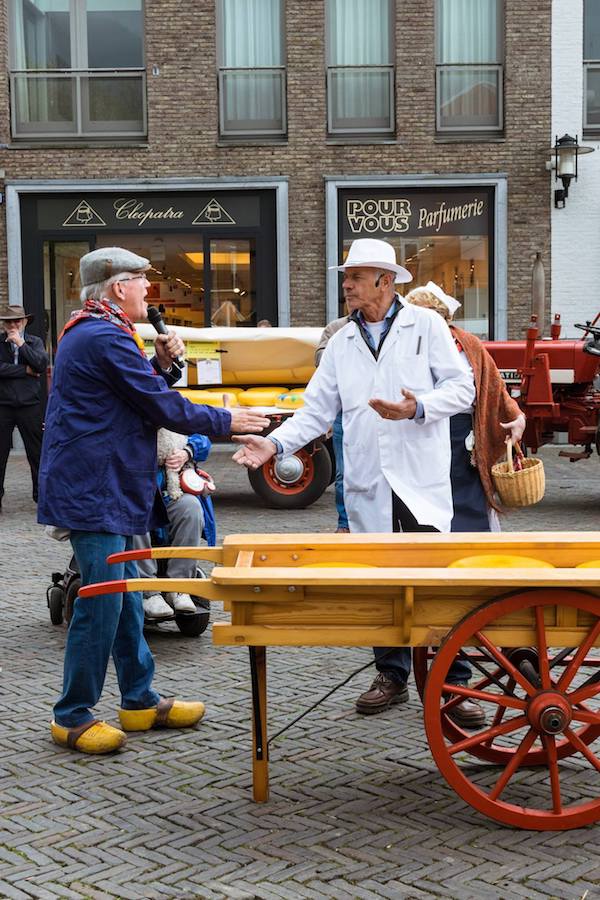 Two men at a Dutch cheese market in Woerden.  This authentic Dutch cheese market is a must for your bucket list in the Netherlands.  Be sure to include a half day in Woerden in your itinerary!