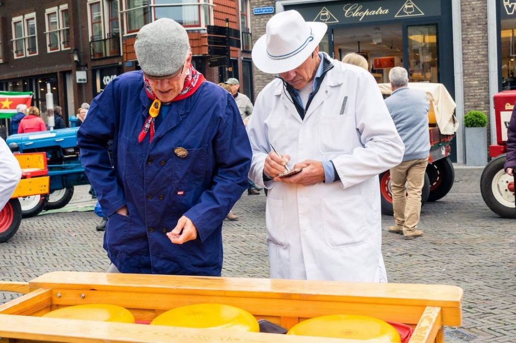 Seller buying the cheese at the Woerden cheese market, a historic cheese market in the Netherlands. The Woerden kaasmarkt is one of the last real cheese markets. #travel #cheese #gouda #netherlands