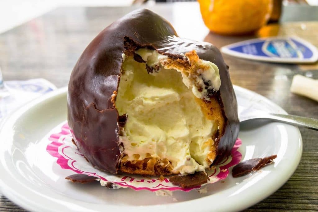 Bossche bol, one of the traditional foods in Den Bosch, the Netherlands. This Dutch sweet is a must-try in Brabant! #travel #denbosch #netherlands #nederland 