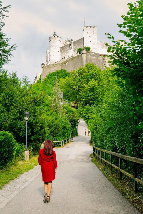Girl stopping for one of the best free views of Hohensalzburg Fortress in Salzburg, Austria.  This insider place is a great place for photos in Salzburg! #salzburg #austria #travel