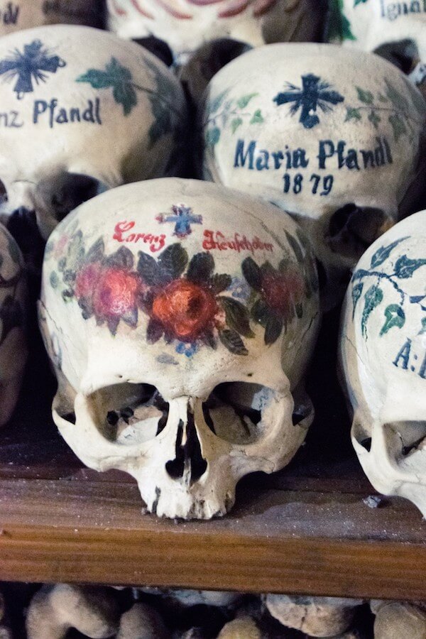 Painted skulls at the Hallstatt ossuary (Beinhaus) with a cross and a name.