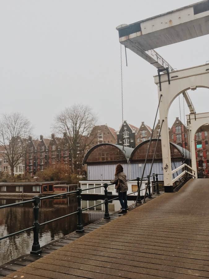 Girl gazing out at the Westelijke Eilanden in Amsterdam.  This neighborhood is still a secret for anyone looking for a beautiful walk in Amsterdam! #amsterdam #travel #holland #netherlands