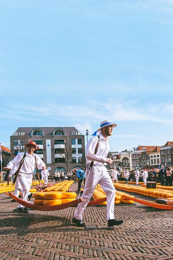 Men carrying cheese at the Alkmaar Cheese Market, one of the highlights of a Alkmaar day trip