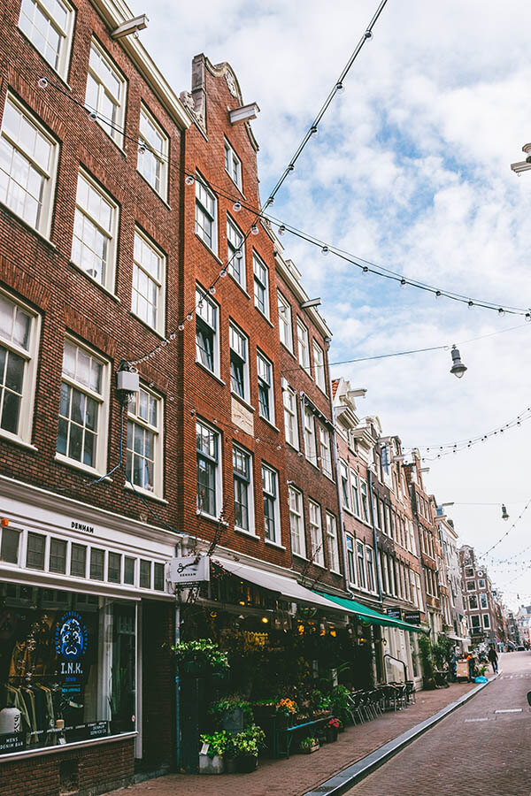 Street view of a street within the Nine Streets neighborhood of Amsterdam, one of the best places to shop in Amsterdam at boutiques! #amsterdam #holland #netherlands #nederland