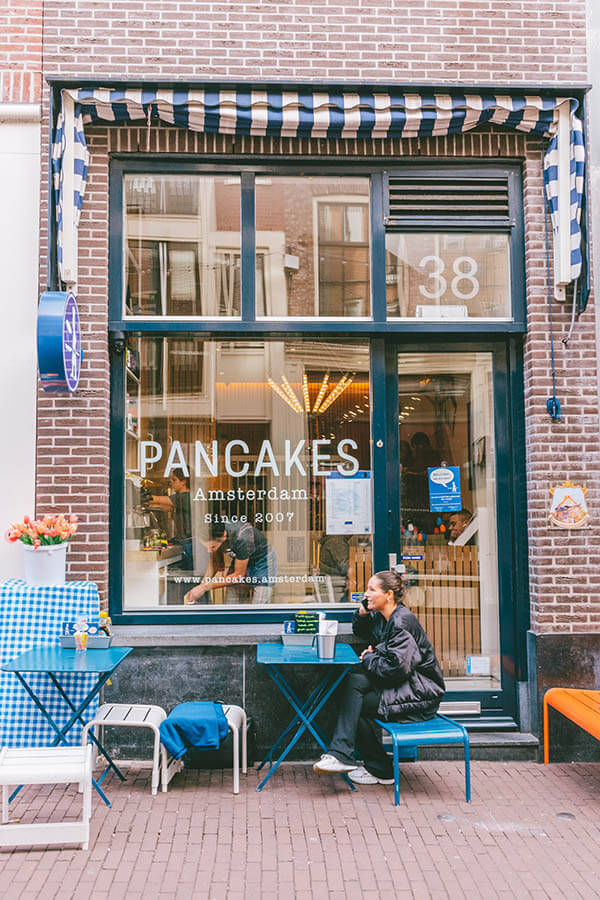 Woman sitting alone at a popular Amsterdam restaurant during a solo trip to Amsterdam #amsterdam