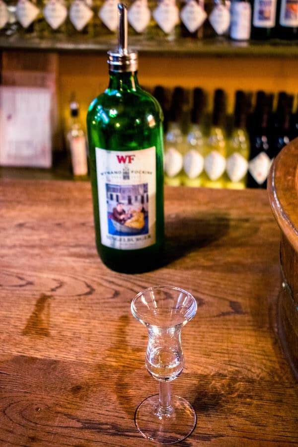 Ein Genever-Glas bei einer Schnapsverkostung bei Wynand Fockink, einem der besten Orte, um Genever, den holländischen Gin, in Amsterdam zu probieren! Diese authentische Bar stammt aus den 1600er Jahren! 