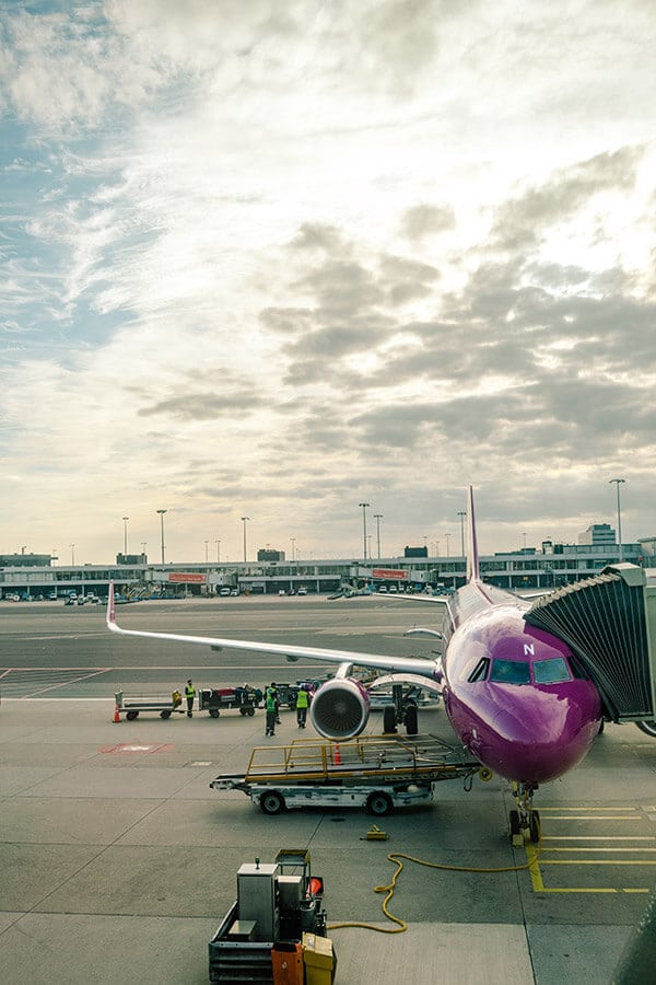 WOW air plane being boarded in New York City.  This cheap airline is a great way to fly from the United States to Europe on a budget! #travel #airlines