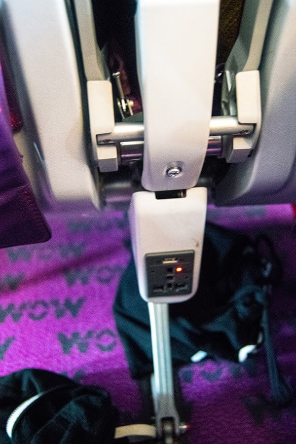 Outlet on board WOW air from NYC to Amsterdam.  There's limited entertainment on board, but you can enjoy watching Netflix offline while plugging in your phone! #travel #airlines