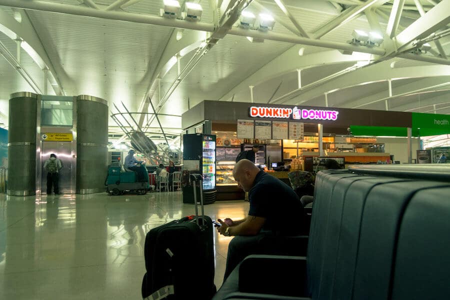 Mann wartet in der Nähe von Dunkin Donuts im Terminal One am JFK über Nacht 
