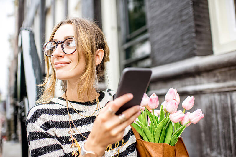 Mädchen telefoniert in den Niederlanden.  Lesen Sie über die besten Apps für das Leben in den Niederlanden!