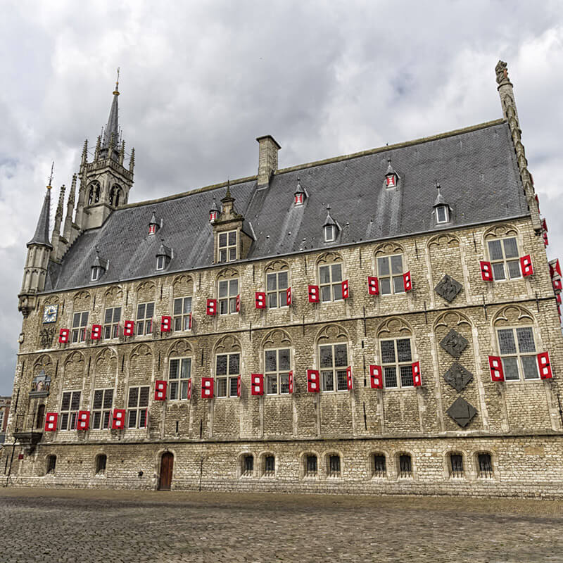 Side view of the Gouda City Hall, one of the most beautiful city halls in the Netherlands. Consider taking a day trip from Amsterdam to see this beautiful building. #travel #netherlands #holland