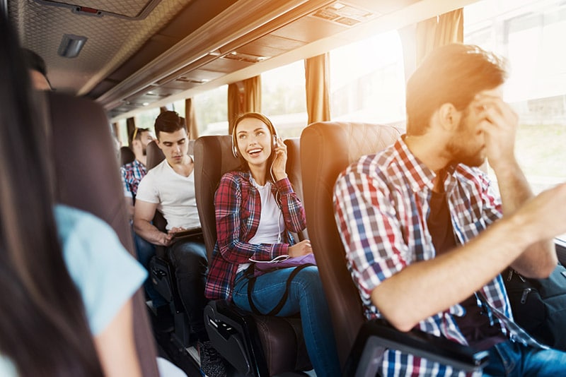 Girl sitting on a bus. Read tips for traveling without a car in the United States and what to know about bus companies in the United States.