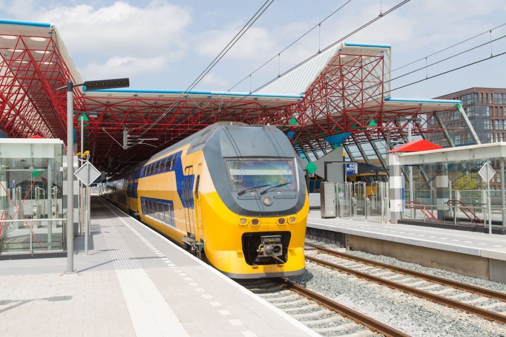 Dutch train leaving Centraal. Read tips for finding cheap train tickets in the Netherlands. #netherlands #expat #travel
