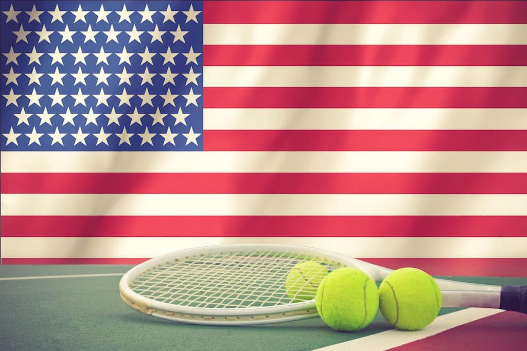 Tennisschläger neben der US-Flagge. Lese über die US Open für Tennis und Tipps für die Teilnahme an den US Open in New York.