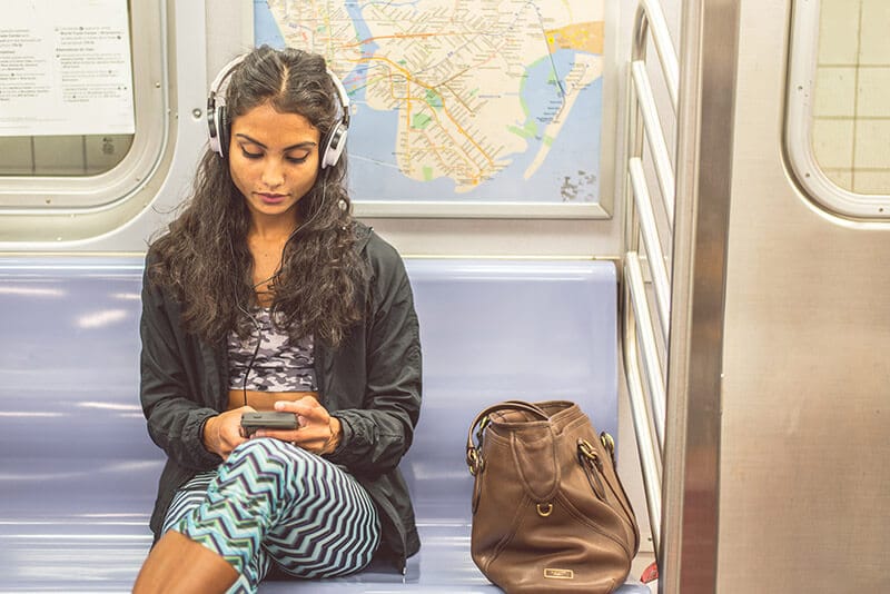 Photo of girl on New York City subway. Read what not to do on the New York City subway with NYC subway etiquette for tourists visiting New York City.