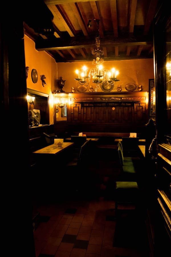 Interior of an old brown bar in Brussels.  This historic cafe in Brussels is the perfect stop-off during your two day Brussels itinerary! #travel #bruxelles #brussels #belgium