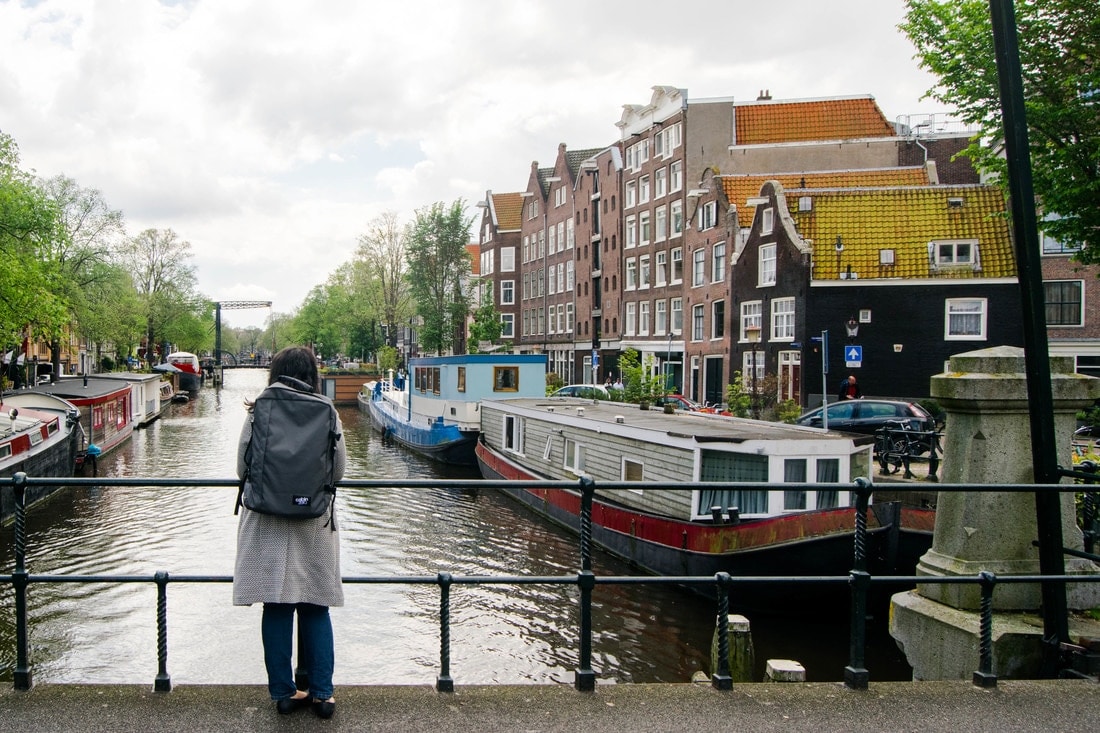 Frau mit Reiserucksack in Amsterdam