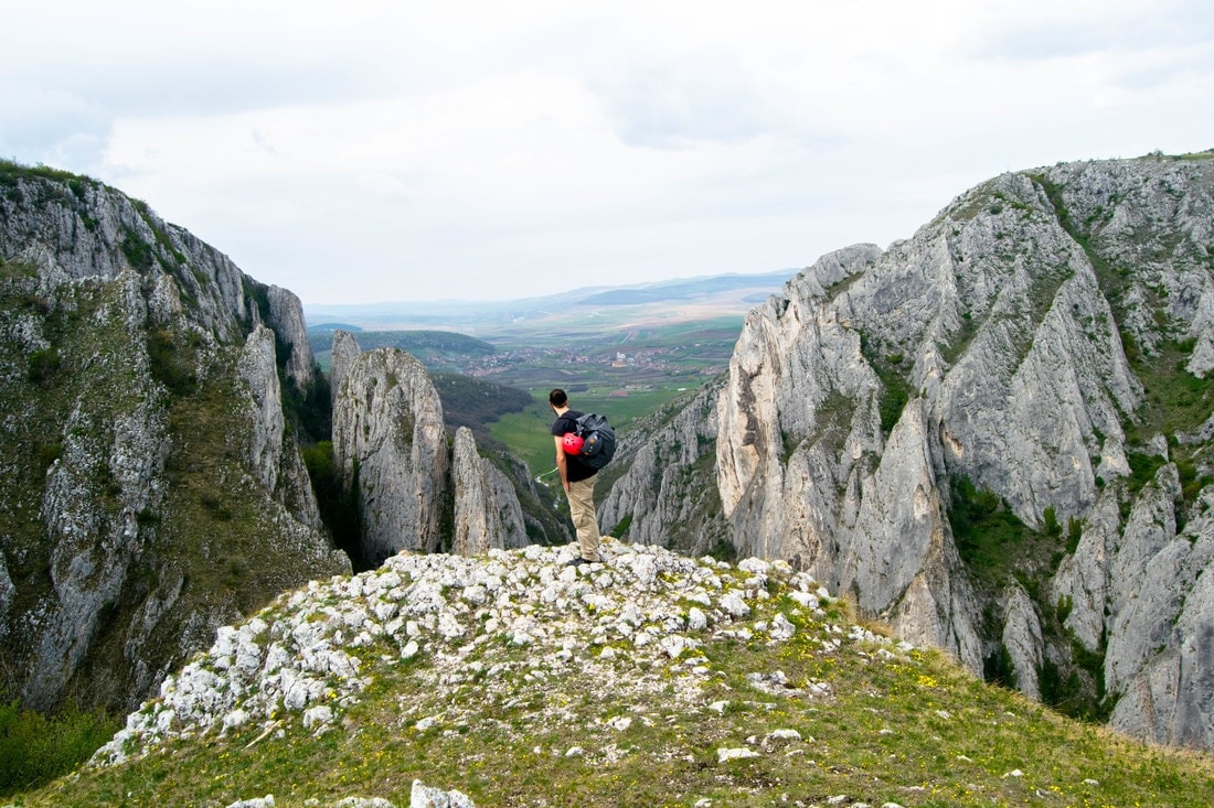 Ein Mann bewundert die Aussicht in Rumänien, einem der besten Orte zum Wandern.