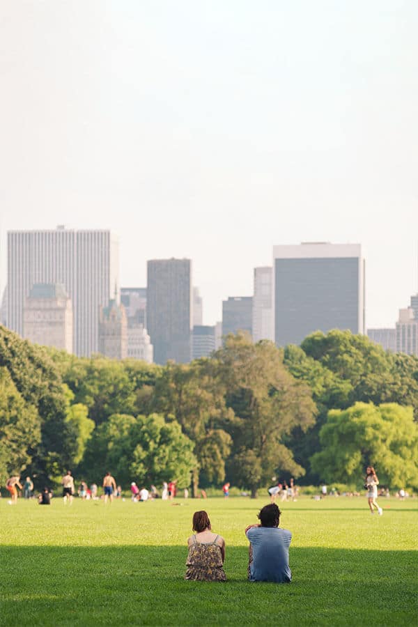 Couple enjoying views of New York City from Central Park.  Explore this beautiful park in New York City as part of the best free things to do in New York City!