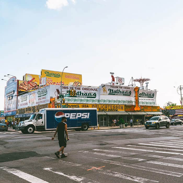 Man walking past the original Nathan's building on Surf. Avenue in Coney Island