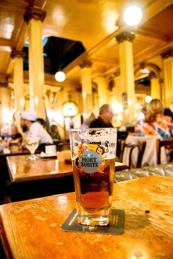 A beer at A La Mort Subtite, one of the classic places to have a beer in Brussels.  This charming cafe in Brussels has a gorgeous interior! #travel #beer #brussels #belgium
