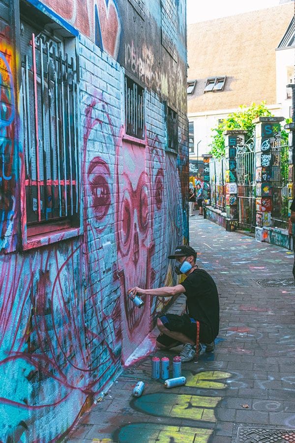 Man painting graffiti on Graffiti Street in Ghent, Belgium!