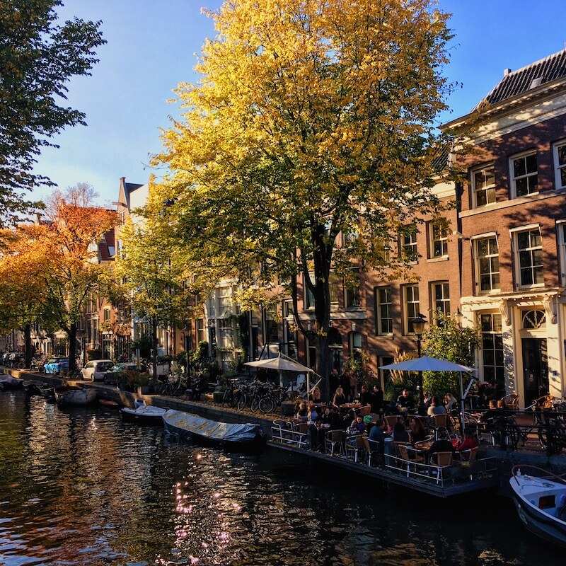 Beautiful picturesque canal in Amsterdam showing beautiful rentals.  Read how to find an apartment rental without losing your mind!