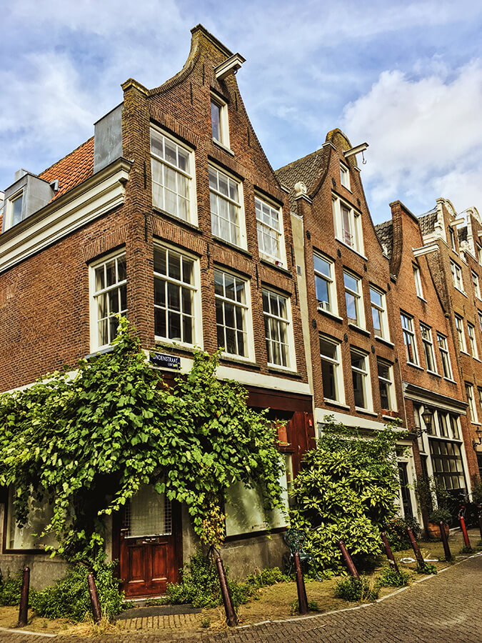 Picturesque houses in the Jordaan along a beautiful street in Amsterdam.  See the prettiest places in Amsterdam! #travel #amsterdam #holland #netherlands