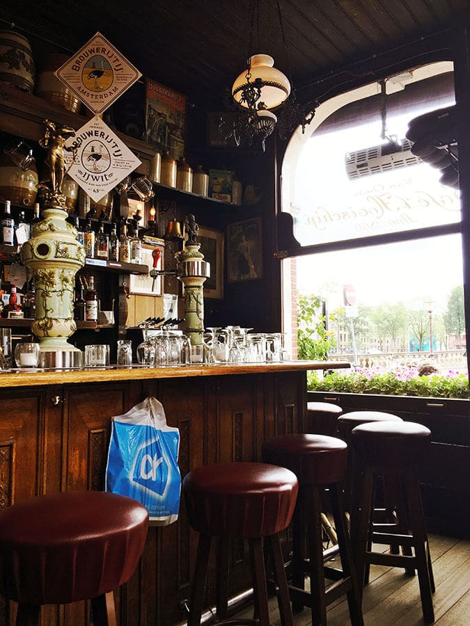 Interior of a cozy cafe in Amsterdam with a beautiful wooden interior; a sign of a classic brown bar in Amsterdam! #amsterdam #holland #netherlands #nederland