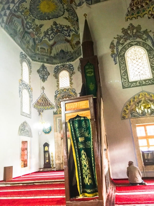 Man praying in the Sinan Pasha Mosque in Kosovo. See why you should visit Prizren Kosovo in the Balkans with photos of Kosovo #Prizren #travel #Balkans 
