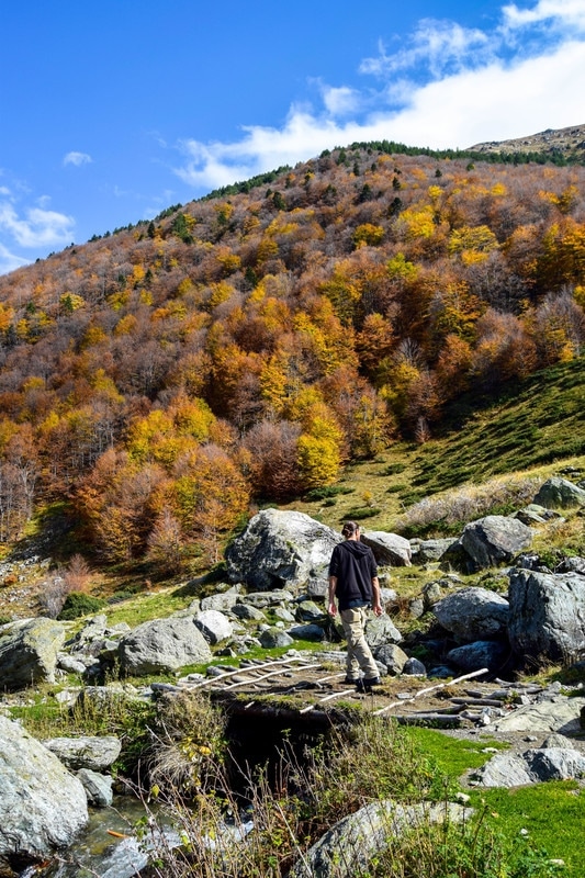 Photo of man on bridge in mountains in Kosovo. See why you should visit Kosovo in fall with beautiful photographs of Kosovo. #fall #Kosovo #Balkans #fall