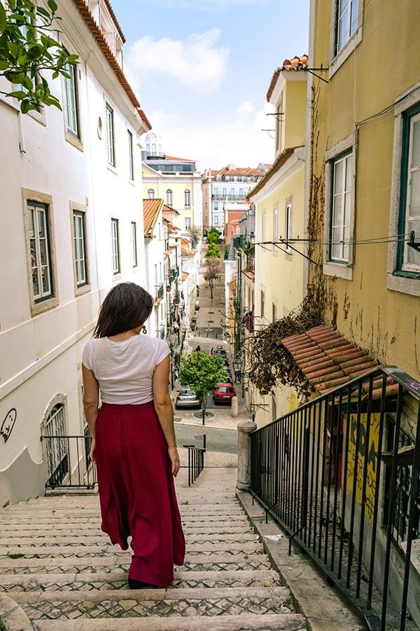 Girl walking down scenic street in Lisbon. 