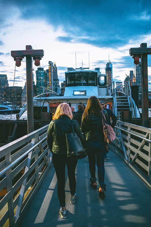 People boarding the New York City ferry from Brooklyn at sunset. 