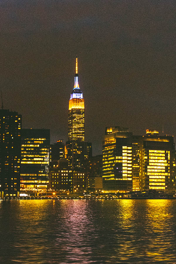 Empire State Building lit up at night seen from the New York City ferry 