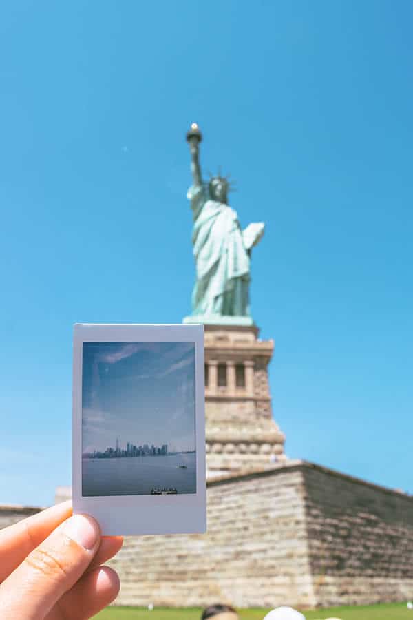 Polaroid of view of Manhattan from the crown of the Statue of Liberty with Statue of Liberty behind it