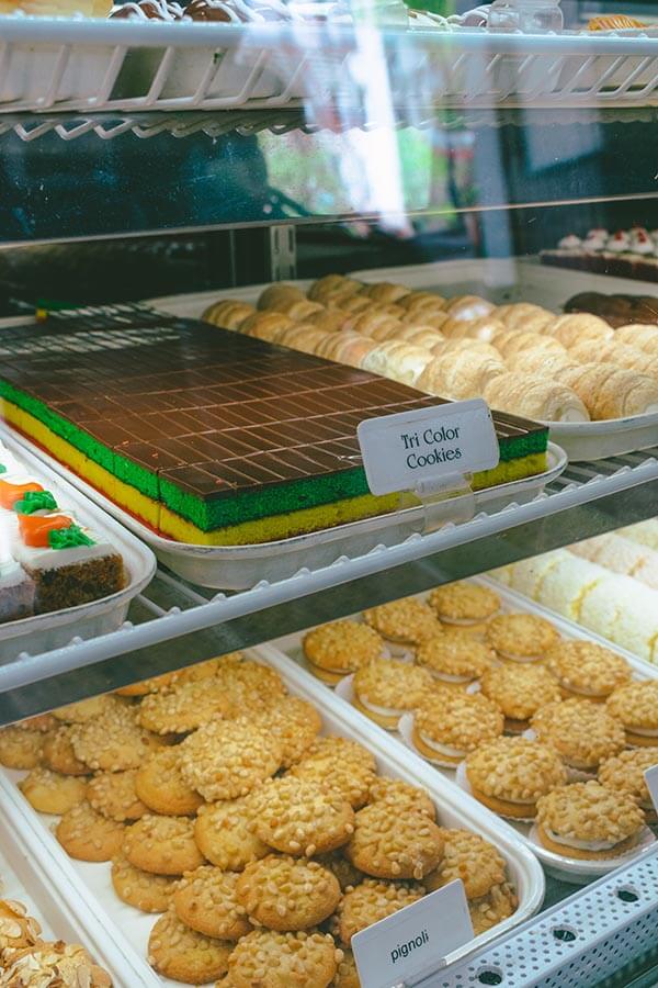 Pastry case with tricolor cookies and pignoli cookies at Artuso Pastry Shop in the Bronx, an institution in Belmont.